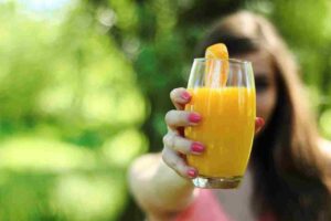 Young woman holding a glass of citrus juice